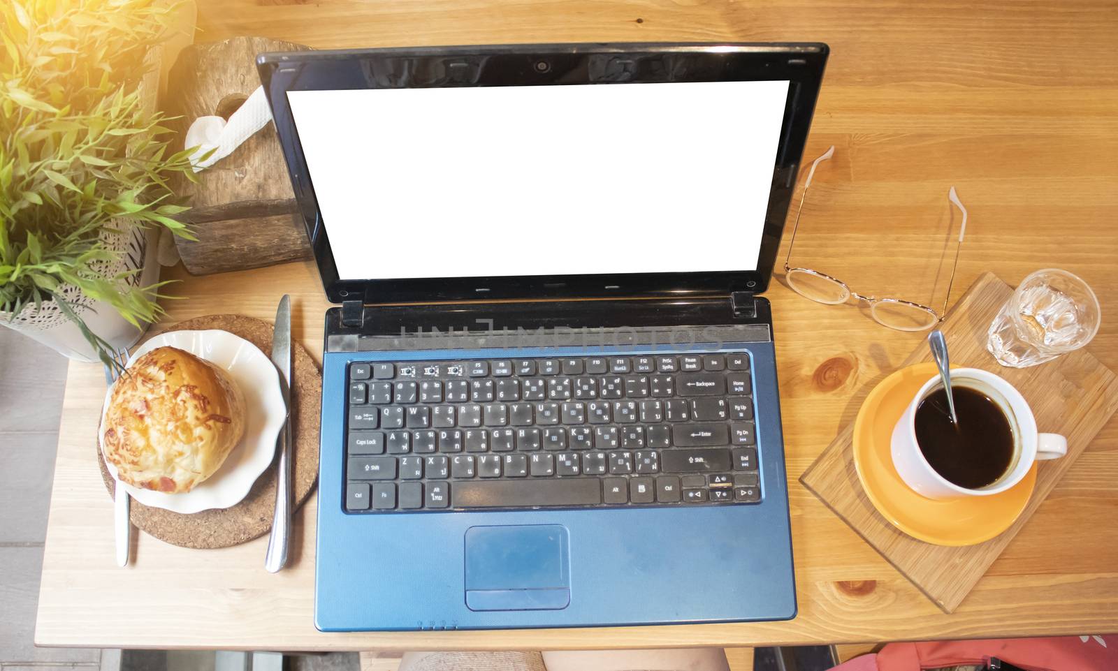 Black coffee in a white cup, bread, and laptop computer ,Top view