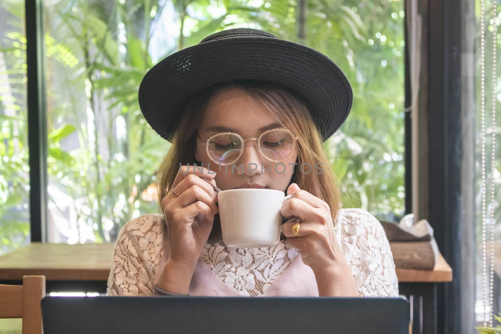 Portrait of attractive young asian woman drinking coffee in cafe