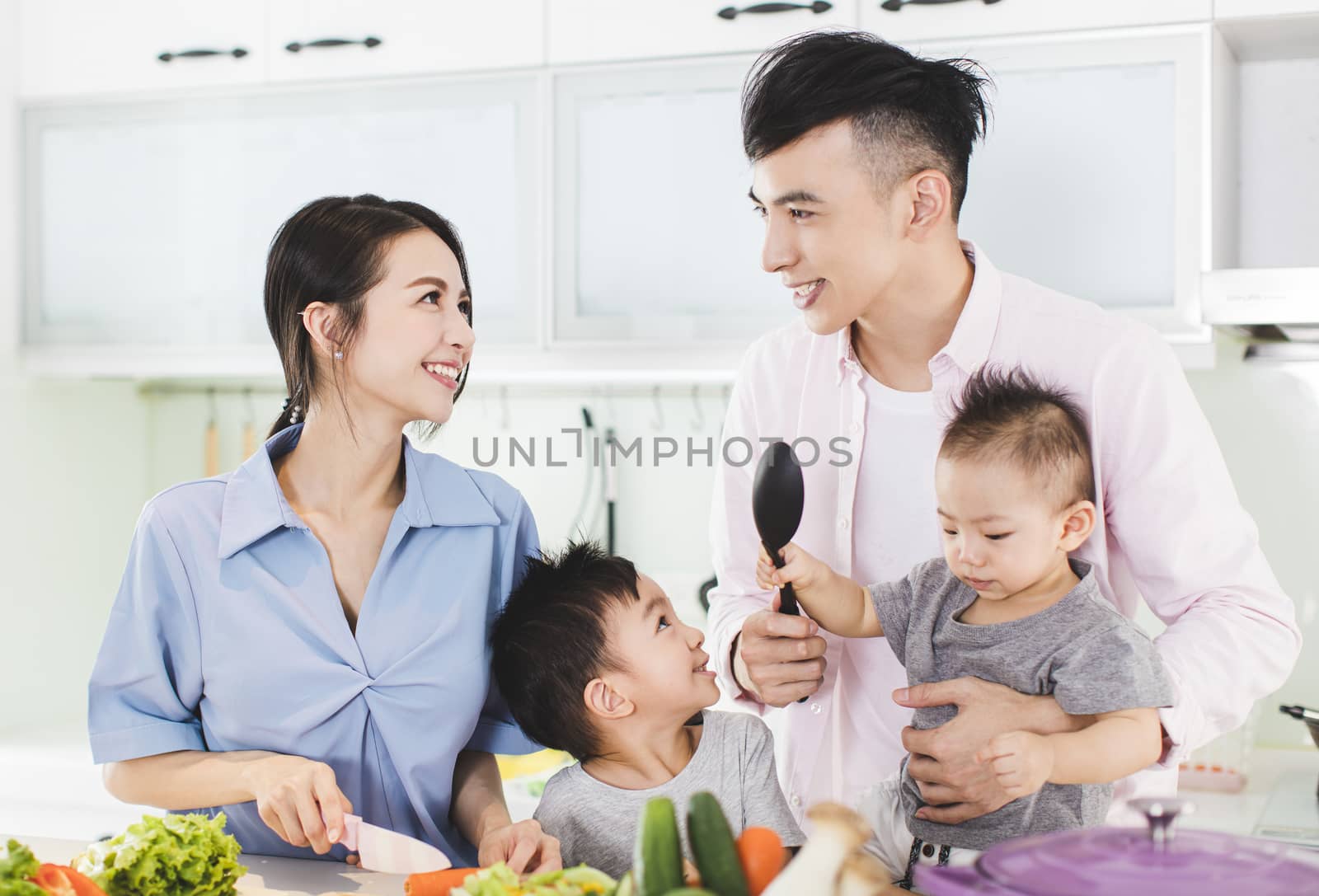 happy family preparing dinner with healthy food in kitchen by tomwang