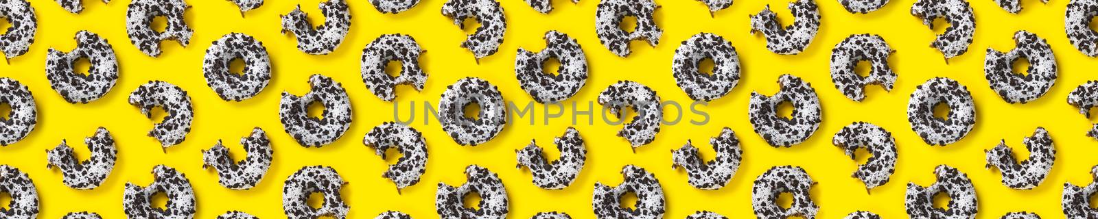 donuts on a yellow background top view. Flat lay of delicious nibbled chocolate donuts. used as donut banner or poster background, not pattern