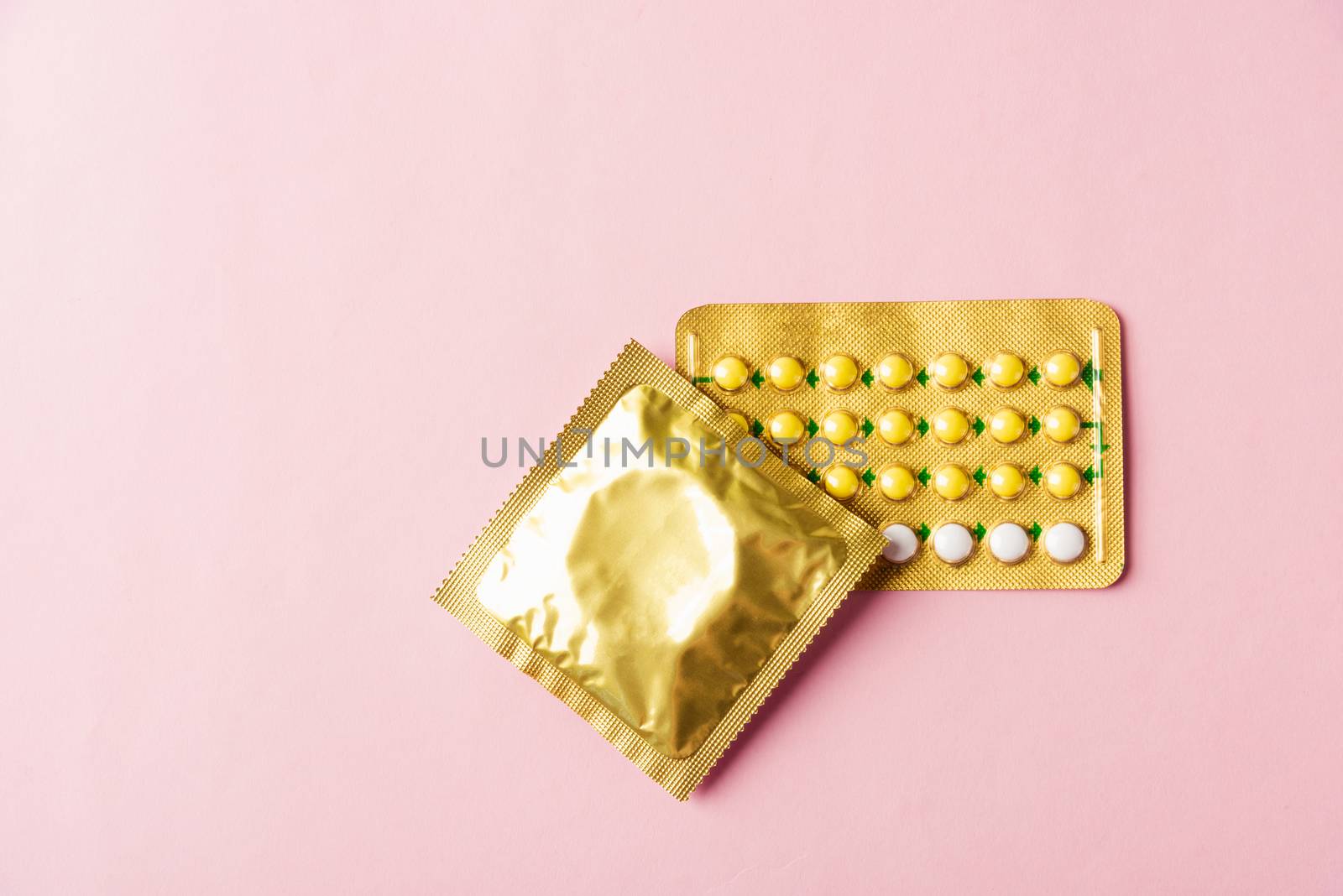Condom in wrapper pack and contraceptive pills blister by Sorapop