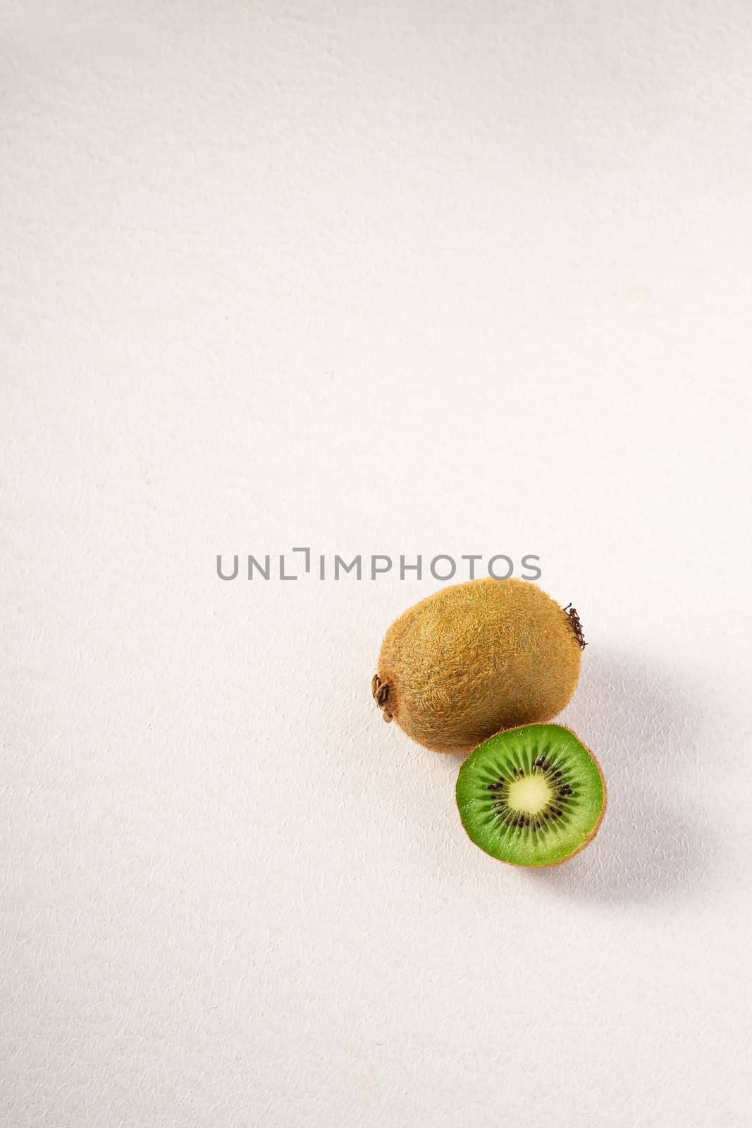 Kiwi fruits half sliced on white background, copy space, top view