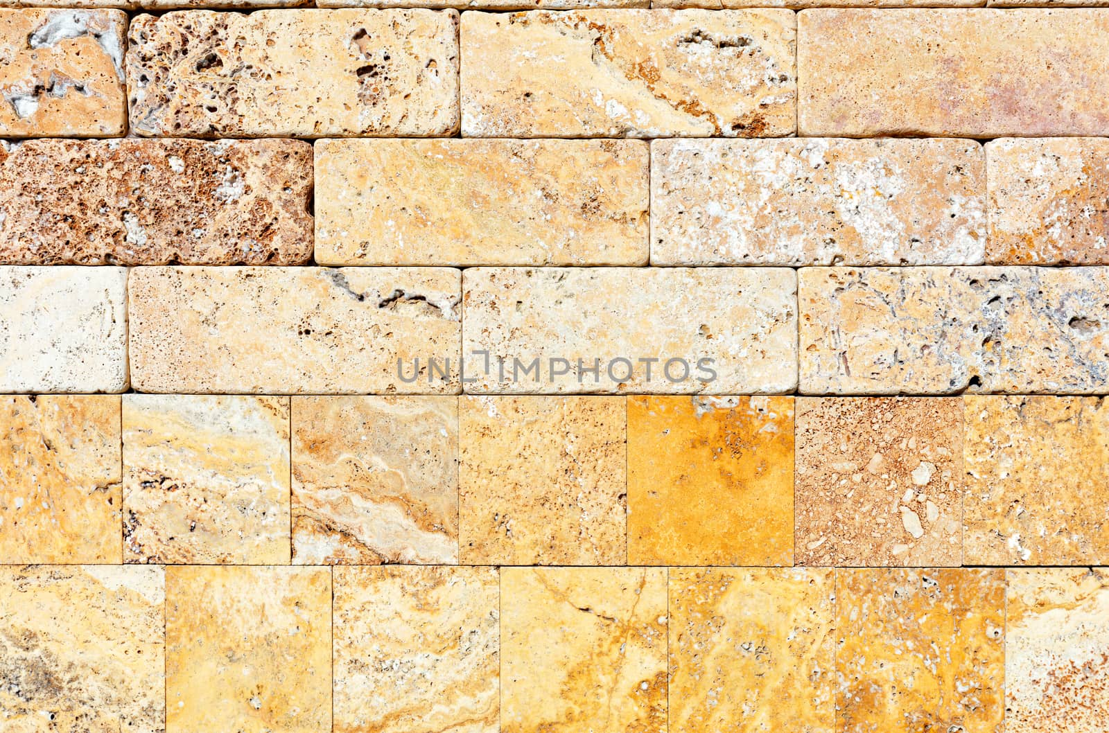 Wall background and texture of hewn yellow seashell stone, close-up.