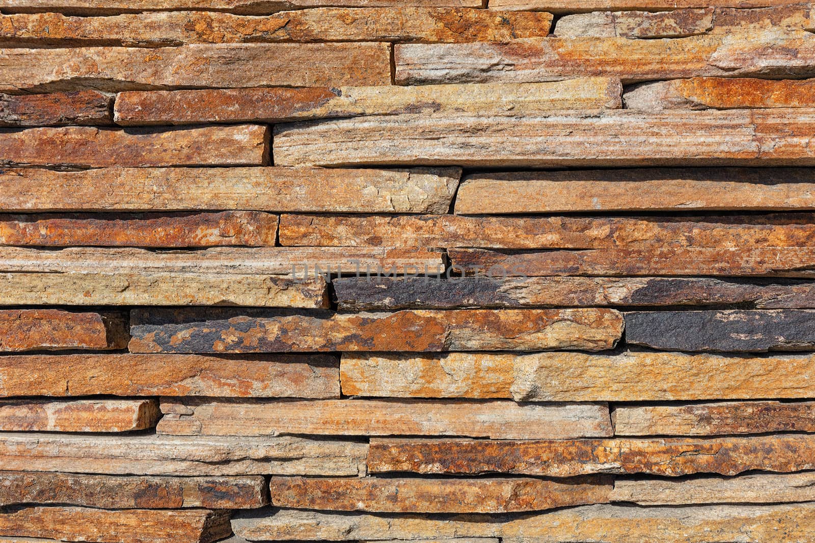 Wall background and texture of brown old slate stone, close-up.