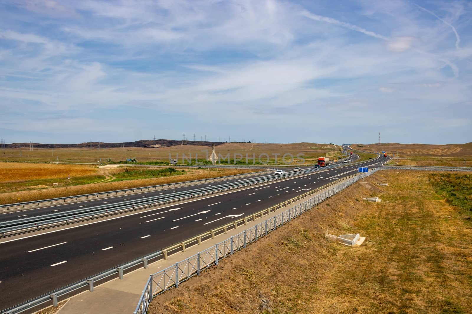 highway in the steppe against the blue sky, a long road stretching into the distance. by lapushka62