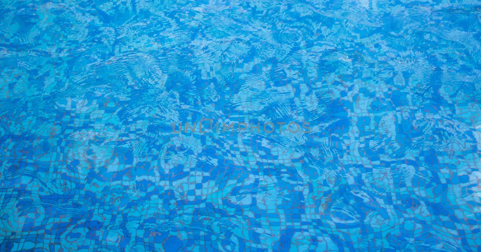 A pool with a mosaic bottom. Blue transparent water ripples. Space for text by lapushka62