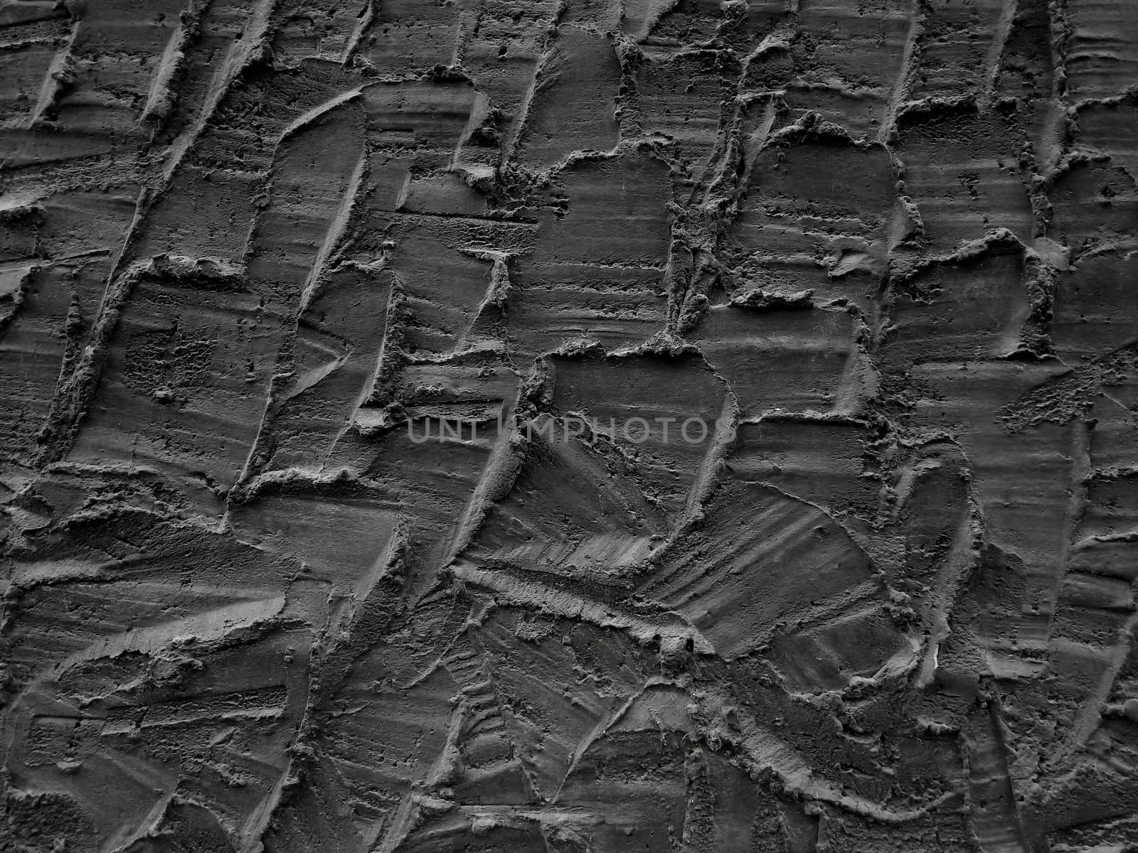 Decorative relief adhesive plaster. Black stucco wall. The black background of the wall.