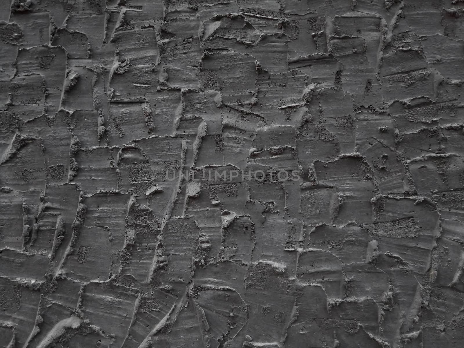 Decorative relief adhesive plaster. Black stucco wall. The black background of the wall.