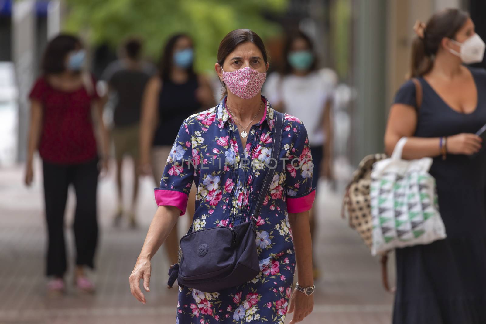 Zaragoza, Spain - August 18, 2020: A woman walking with face mask, due to the coronavirus pandemic, in the central area of Zaragoza.