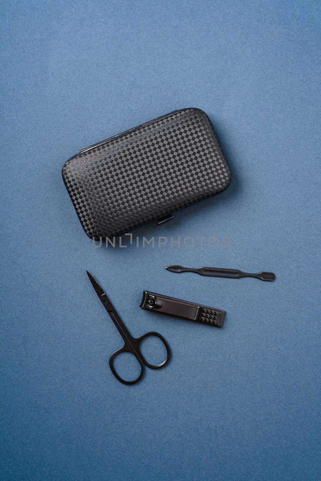 Set of manicure and pedicure tools and accessories near to case, top view, blue background