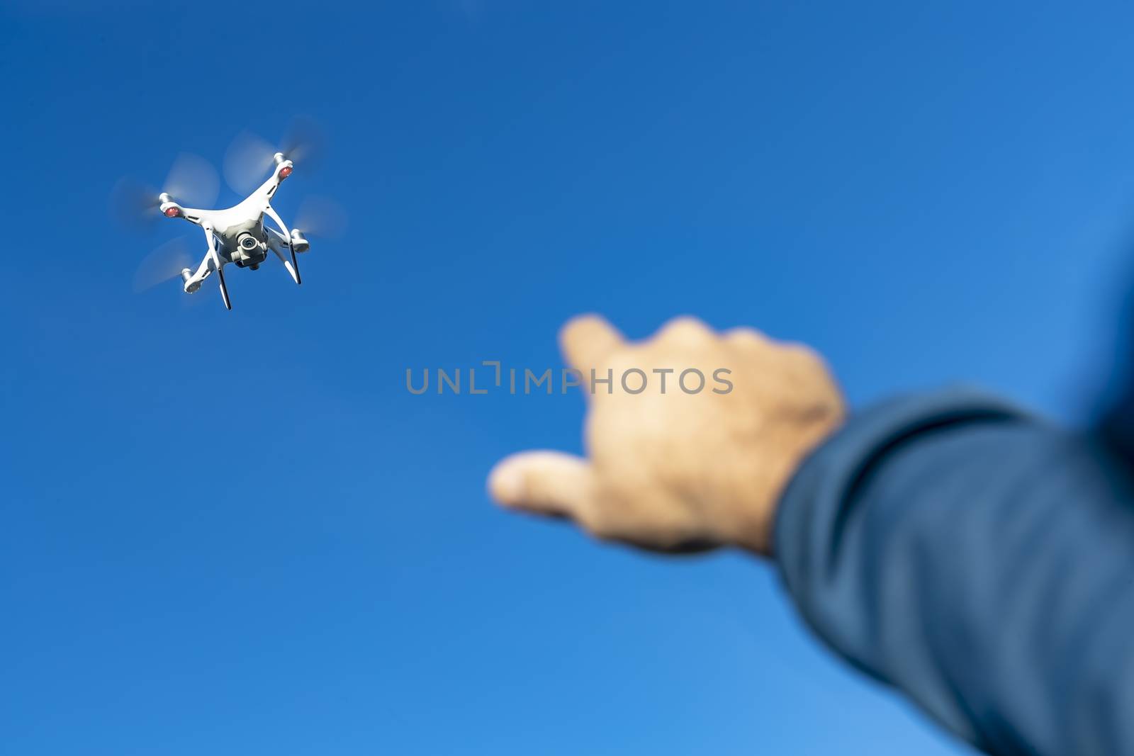 A group of drones fly through the air against a blue sky