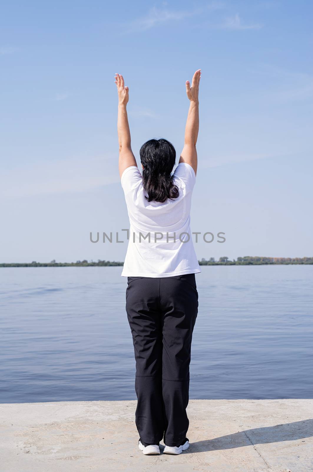 Sport and fitness. Senior sport. Active seniors. Active and happy senior woman exercising near the riverside