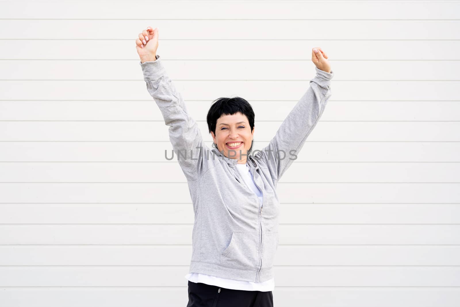 Sport and fitness. Senior sport. Active seniors. Senior woman stretching her legs outdoors on the sports ground