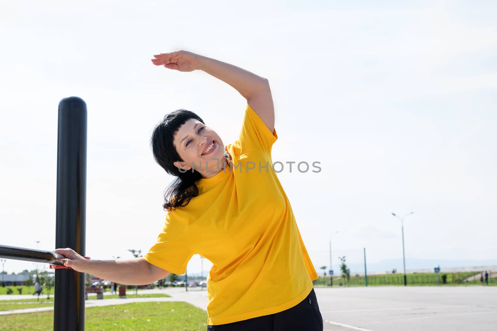 Sport and fitness. Senior sport. Active seniors. Senior woman doing stretching stretching outdoors on the sports ground