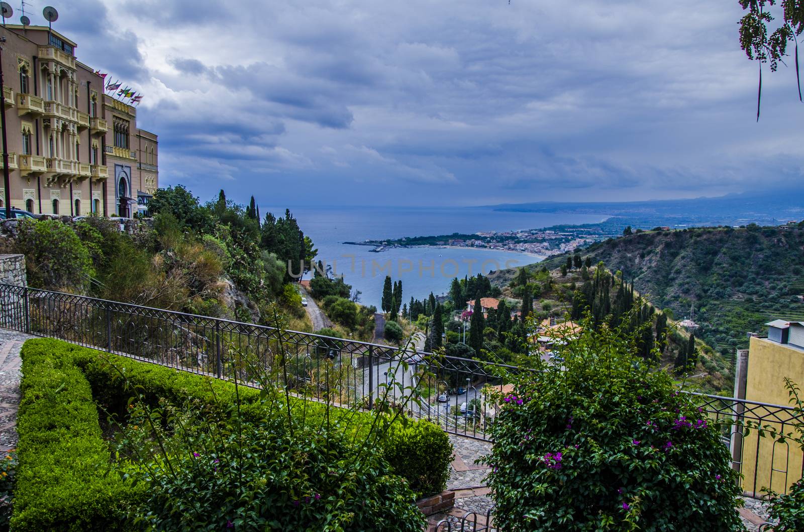 Partial view of the city of taormina with the sicilian coast as horizon a day with clouds