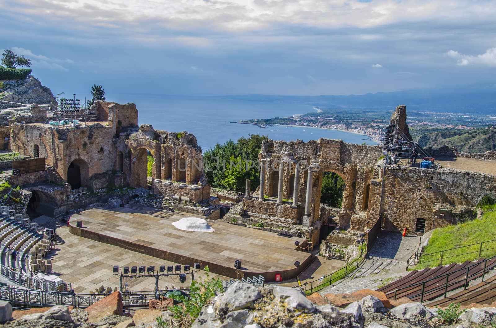 Close-up of the remains of the ancient theater of taormina and panoramic of the coast as background sicily