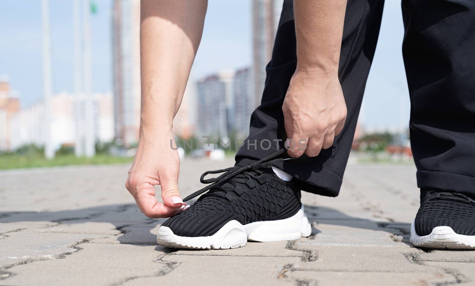 Sport and fitness. Senior sport. Active seniors. woman fastening shoe laces on her snickers outdoors