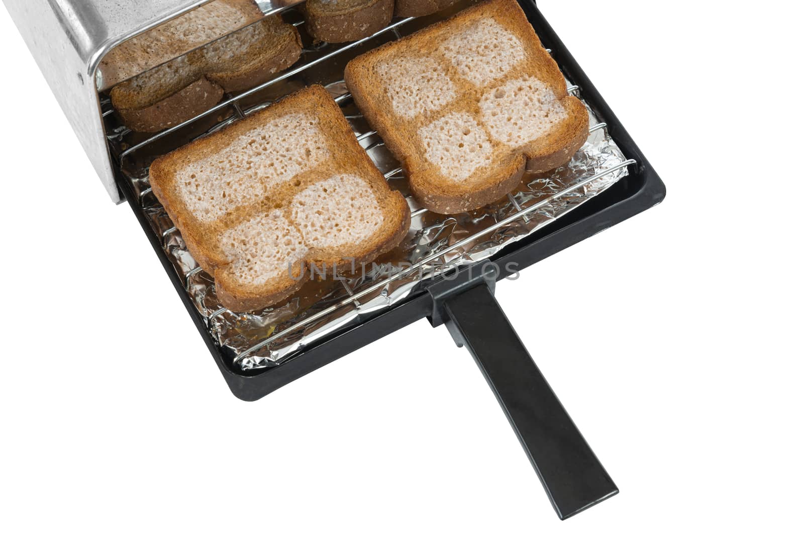 Horizontal shot of a toaster tray with four pieces of buttered wheat bread coming out of a toaster.