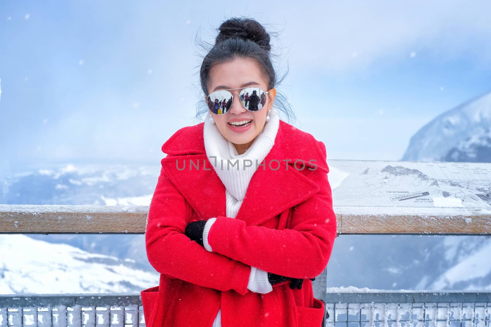 Beautiful young woman playing with snow in fur red coat outdoors