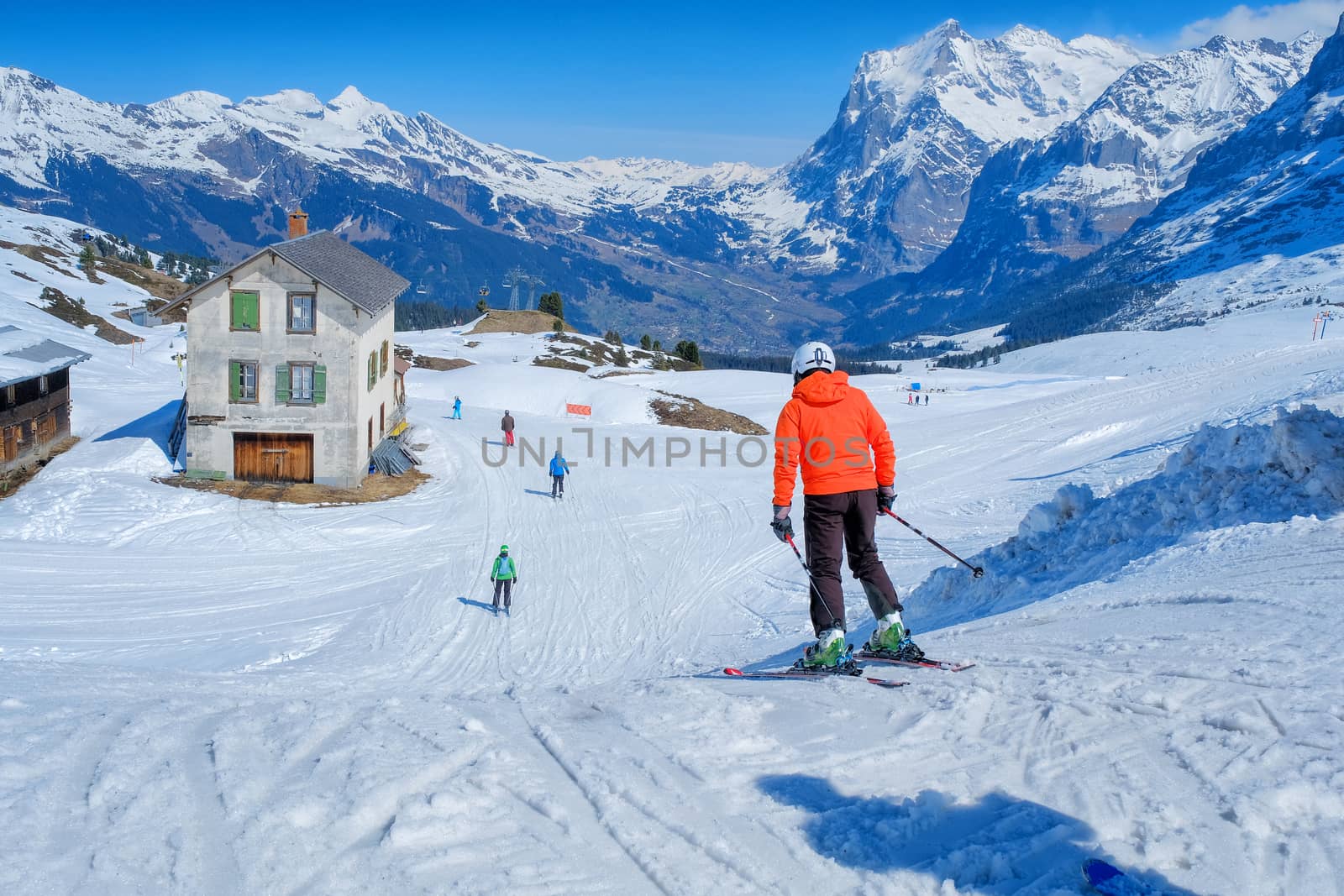 Skier skiing downhill in high mountains Kleine Scheidegg station at Switzerland