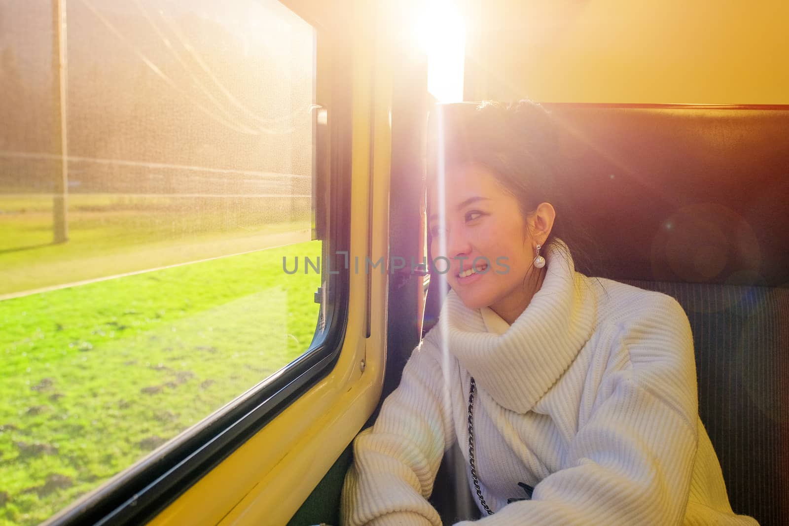 Young beautiful woman traveling looking view while sitting in the train.