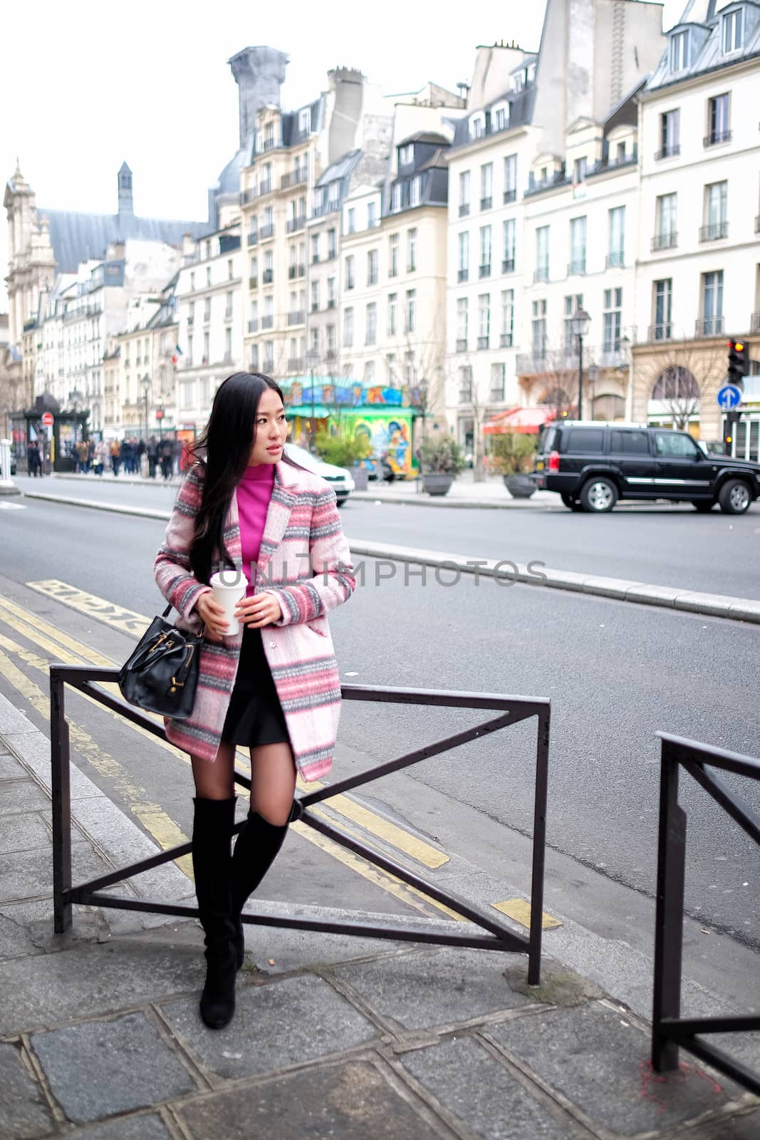 Beautiful young woman in the street drinking morning coffee