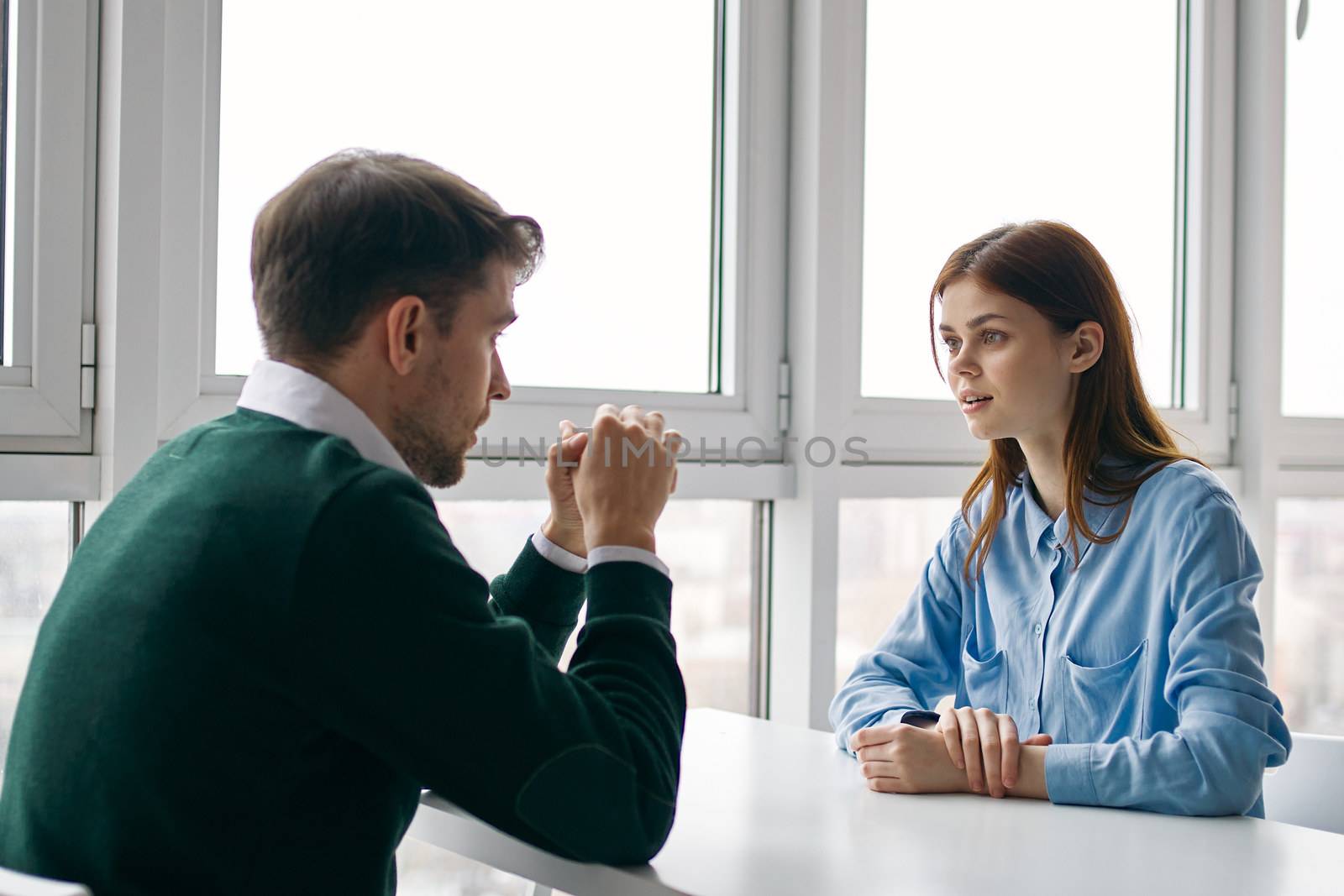 woman looks with surprise at the man at the table indoors by SHOTPRIME