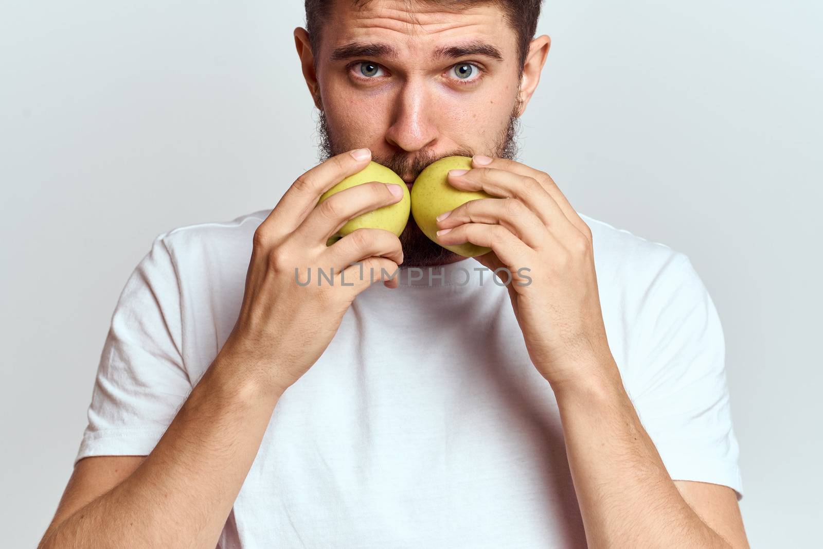 Energetic man with apples health vitamins diet and lifestyle white t-shirt cropped view by SHOTPRIME