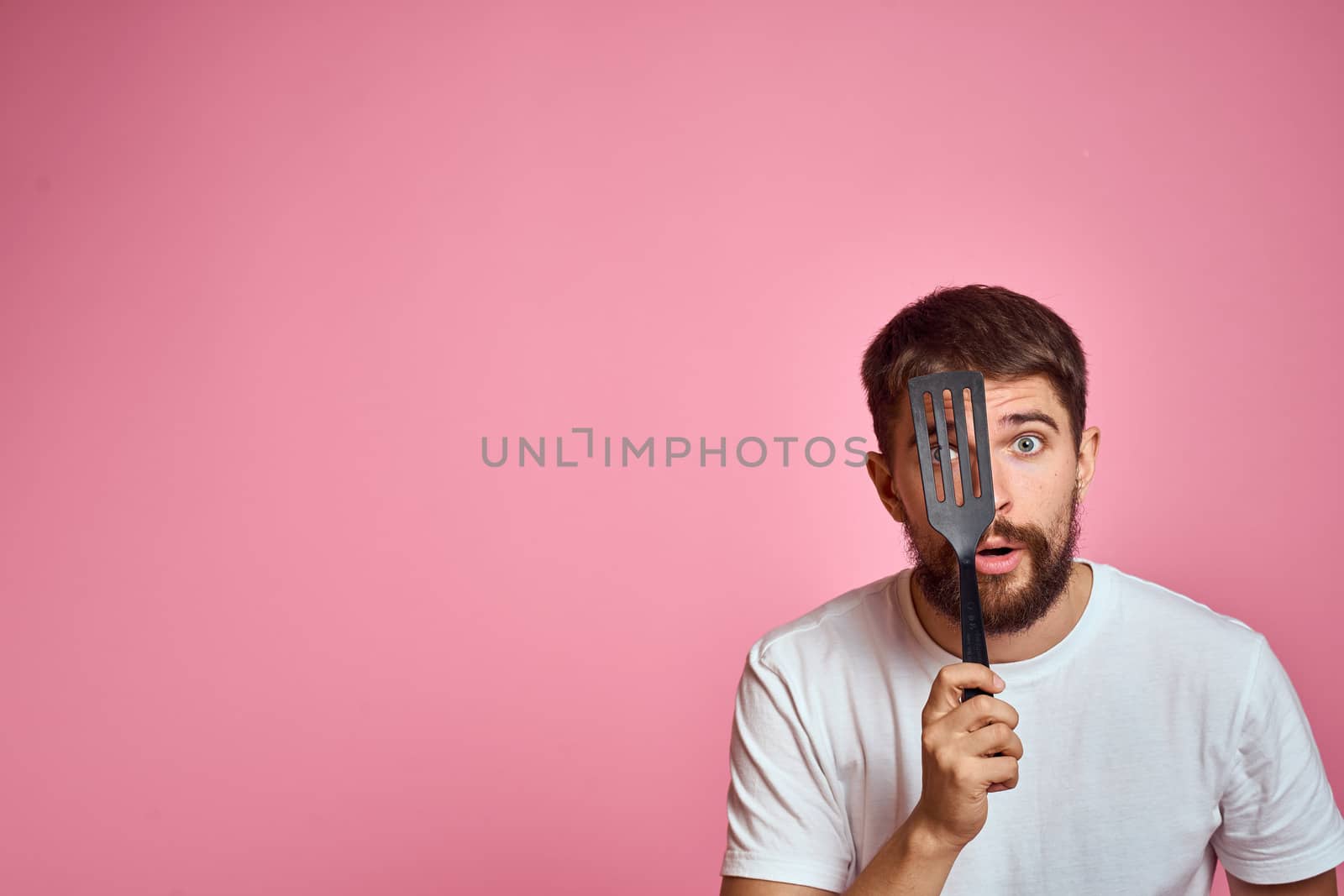 Man with spatula in hands kitchen accessories model emotions pink background cropped view Copy Space by SHOTPRIME