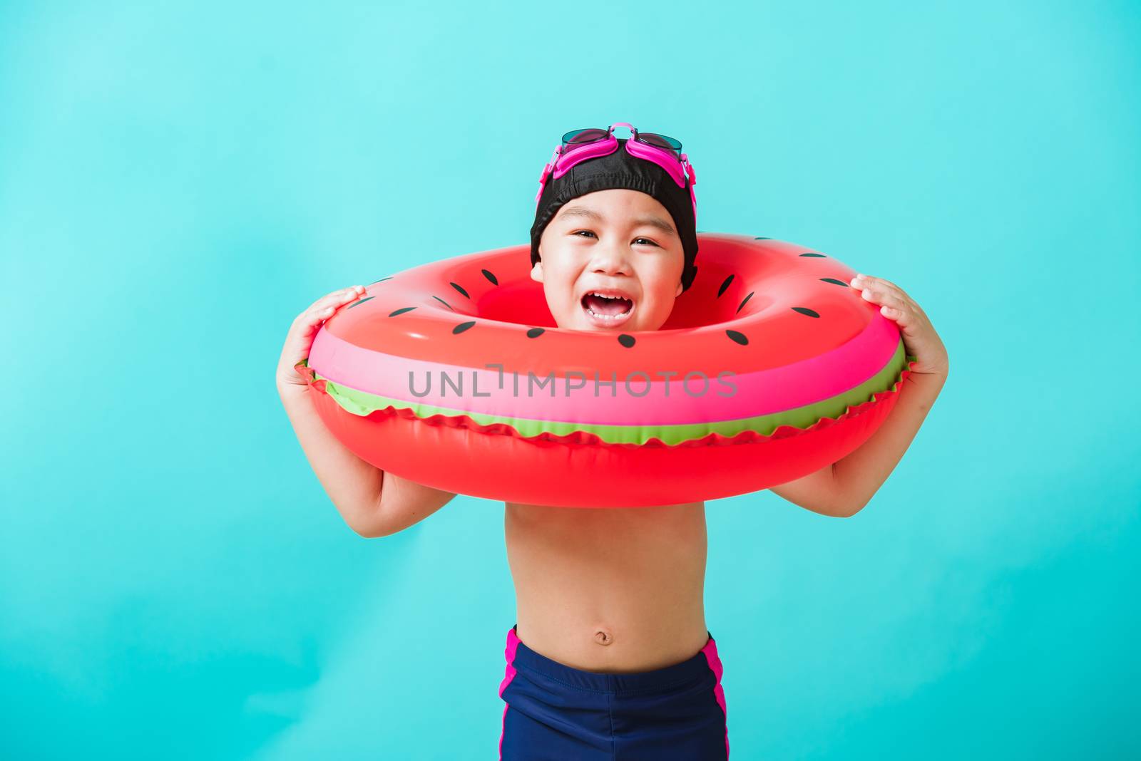 Child boy wearing goggles and swimsuit holding beach watermelon  by Sorapop