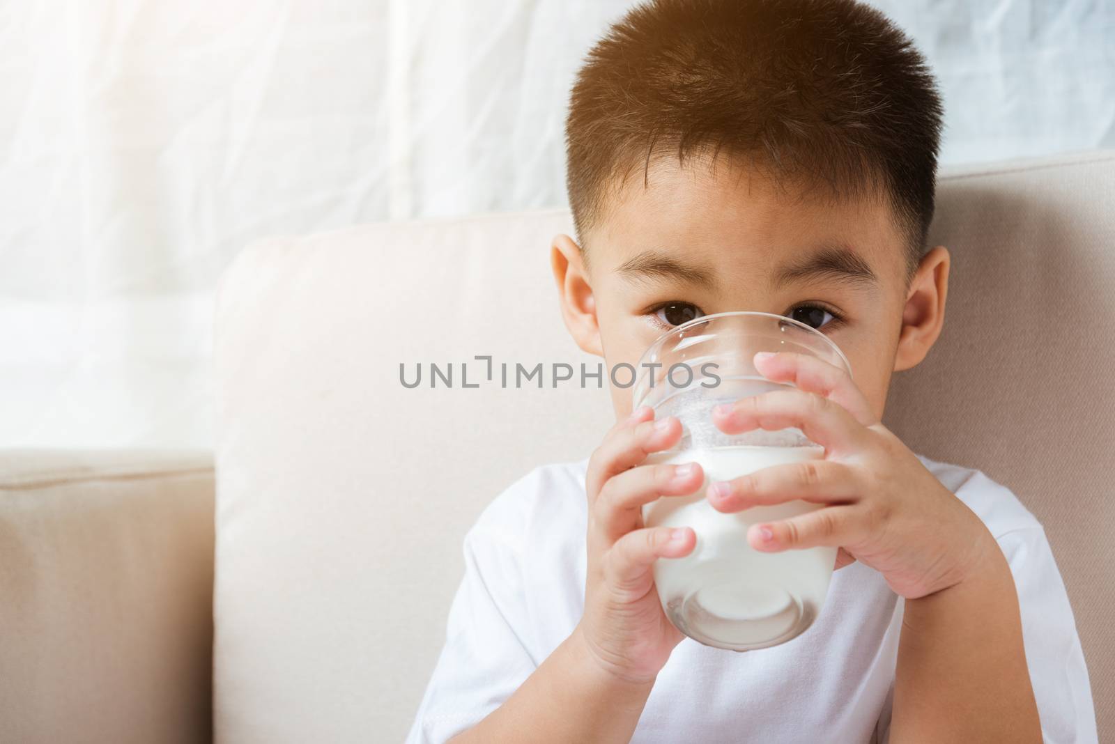 Little child boy hand holding milk glass he drinking white milk by Sorapop