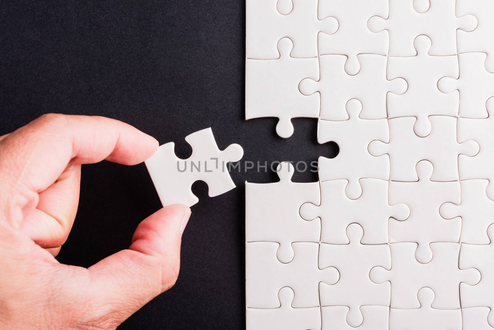 hand-holding last piece white paper jigsaw puzzle game last piec by Sorapop