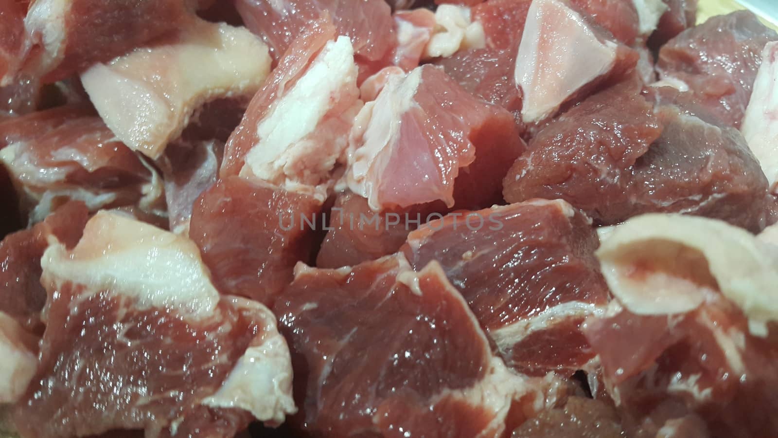 Close up view of fresh finely chopped meat cubes. Red meat small steaks with whitish meat fat.