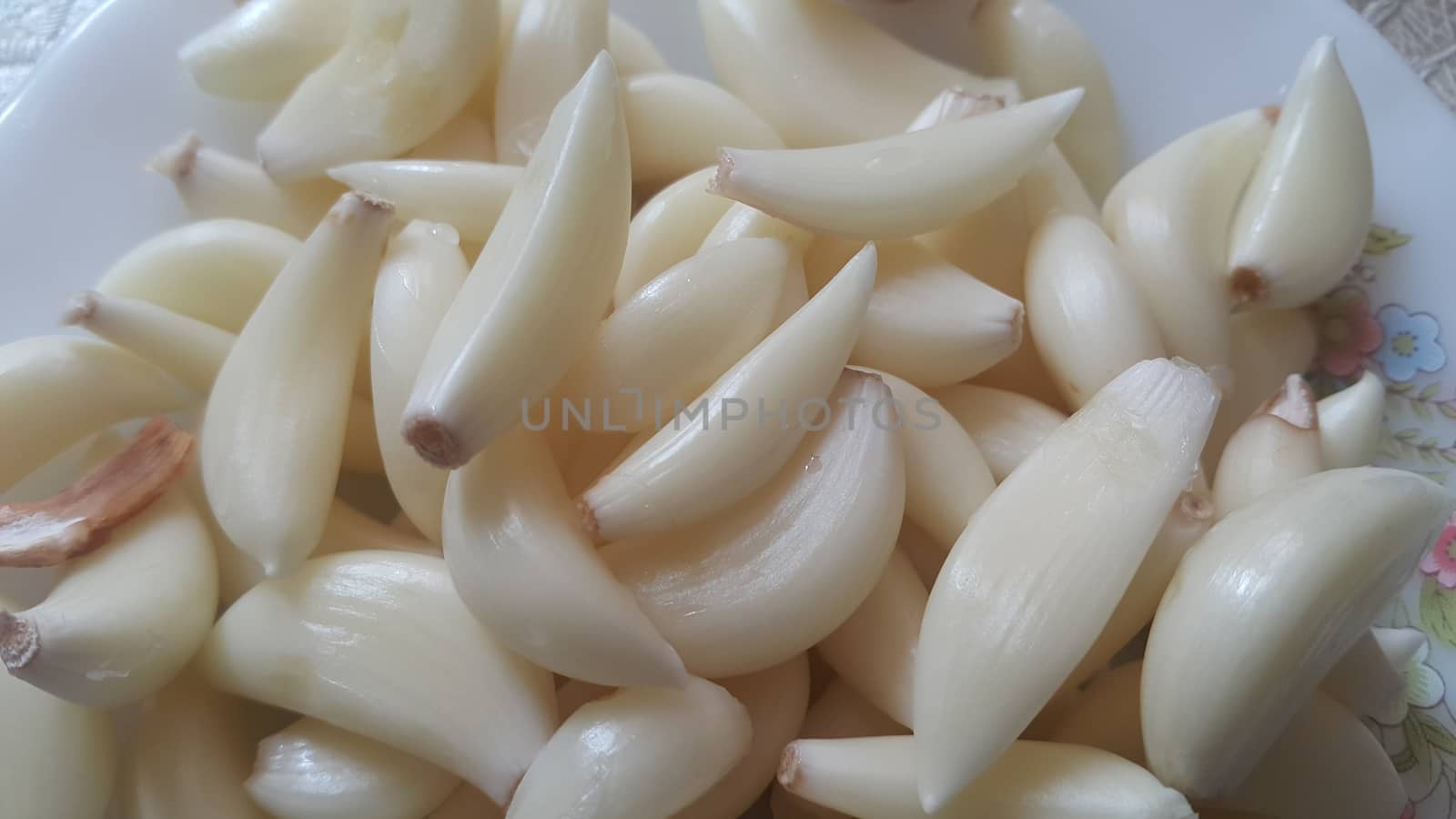 Garlic is aromatic and flavorful herb for consumption and use in spices and for medicinal purposes. Close-up view of dry peeled garlic clove background