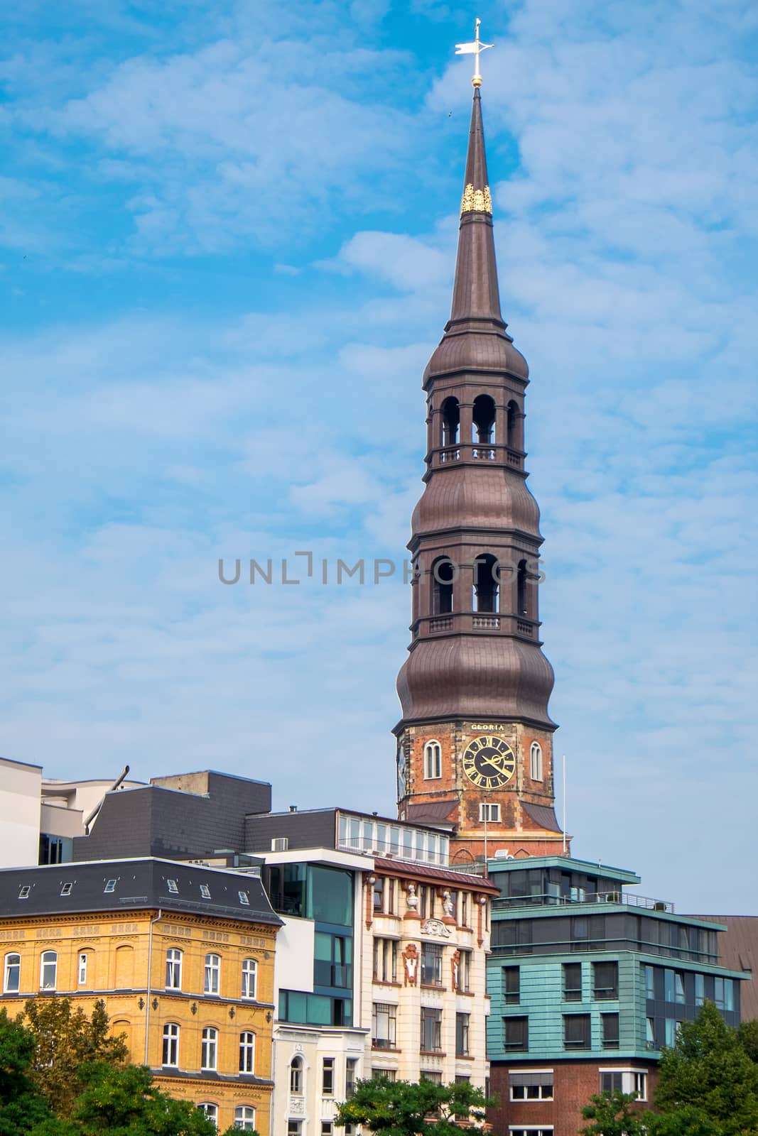 The tower of the Church of St. Catherine and some old houses in Hamburg, Germany