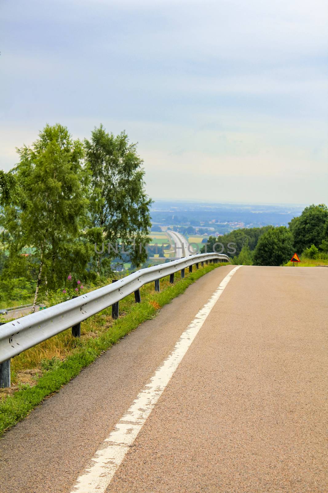 Road from the rest area to the motorway in Sweden. by Arkadij