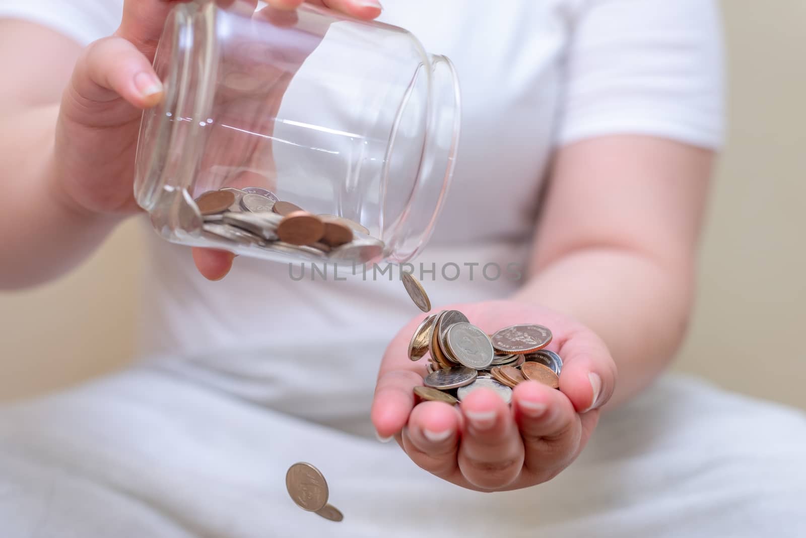 Save money and account banking for finance concept, Hand with coin bottle blurred background