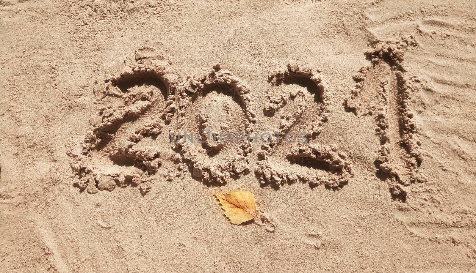 The concept of a New year. Heart and numbers 2021 in the sand. Summer beach holidays . The message is handwritten by lapushka62