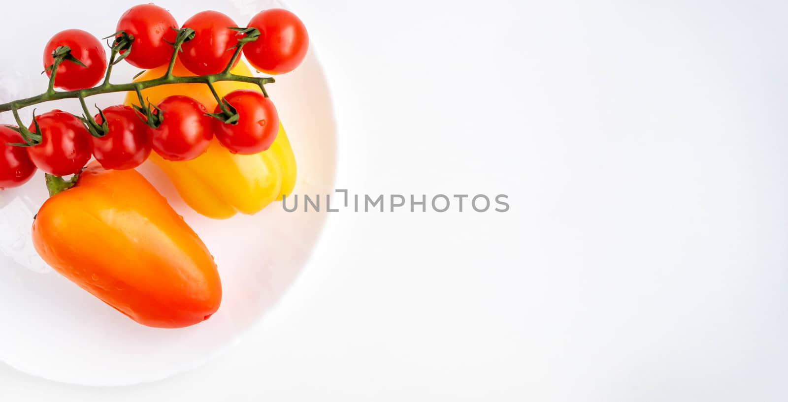 Fresh vegetables a sprig of cherry tomatoes and two orange peppers isolated on a white background.Space for your text by lapushka62