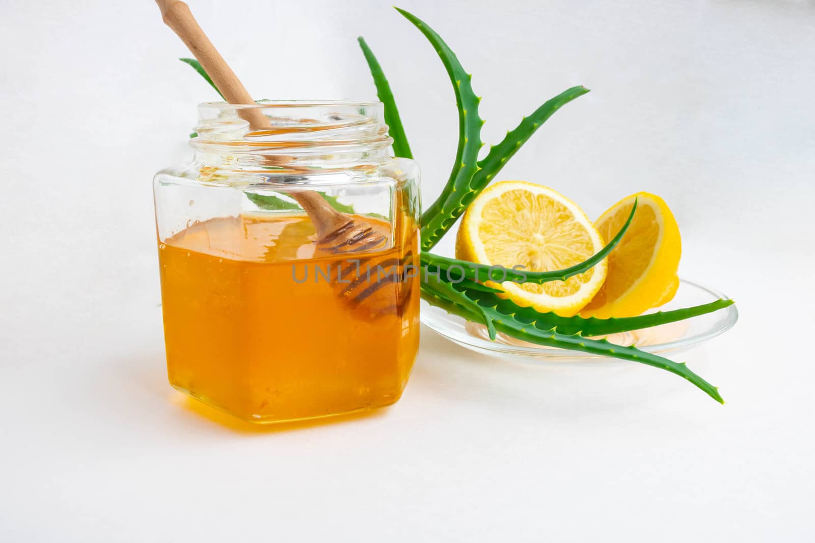 Useful ingredients for strengthening the immune system on a white background.Honey in a jar, lemon and aloe Vera. Space for text by lapushka62