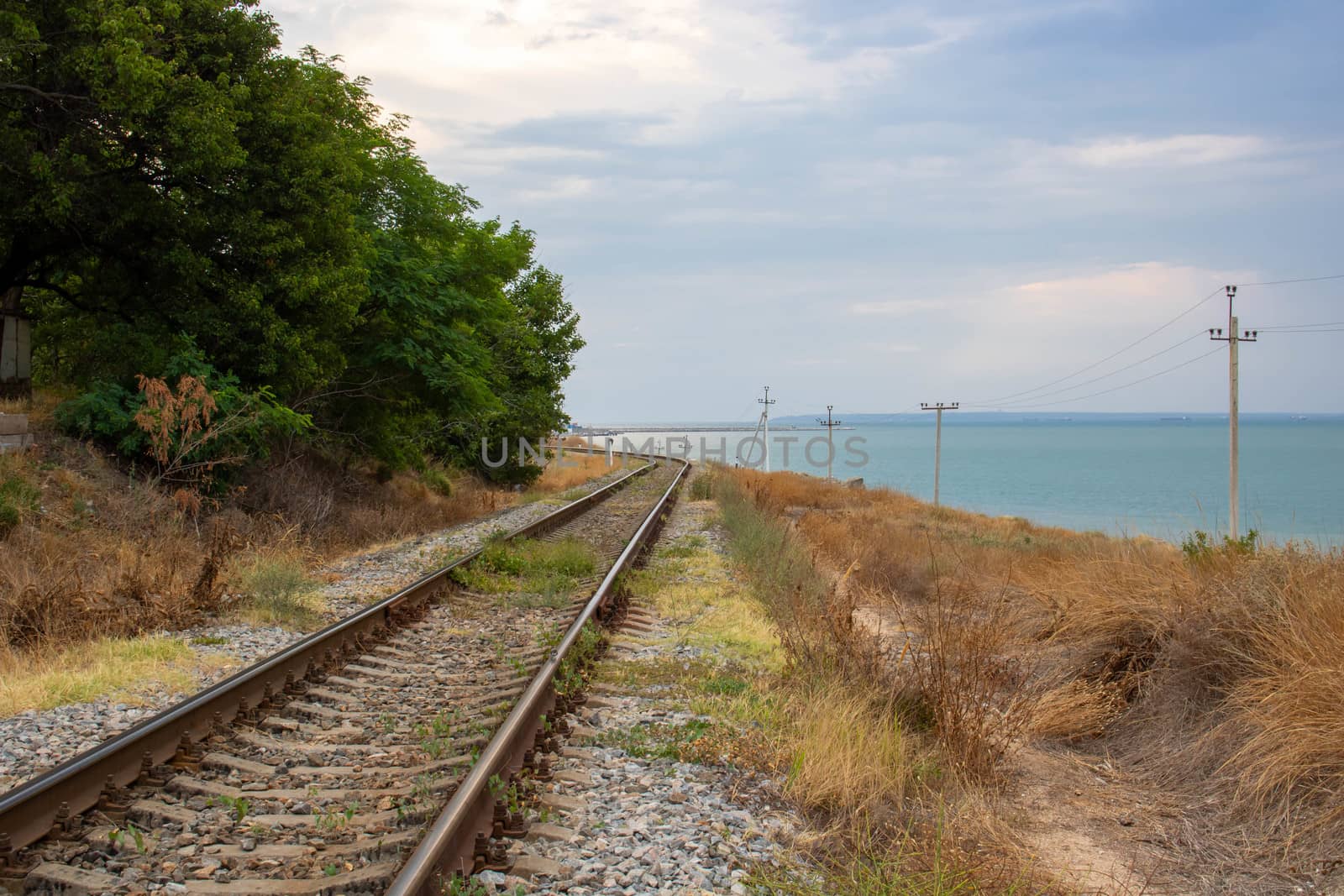 The old railway runs along the coast along the sea.Space for tex