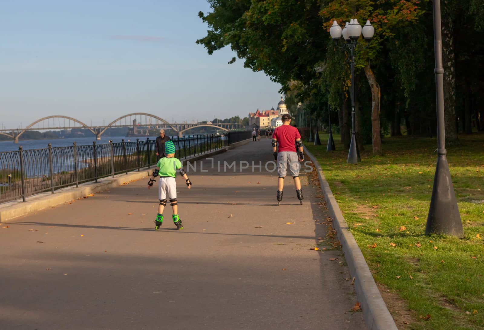 Father teching son roller skating in park by lapushka62