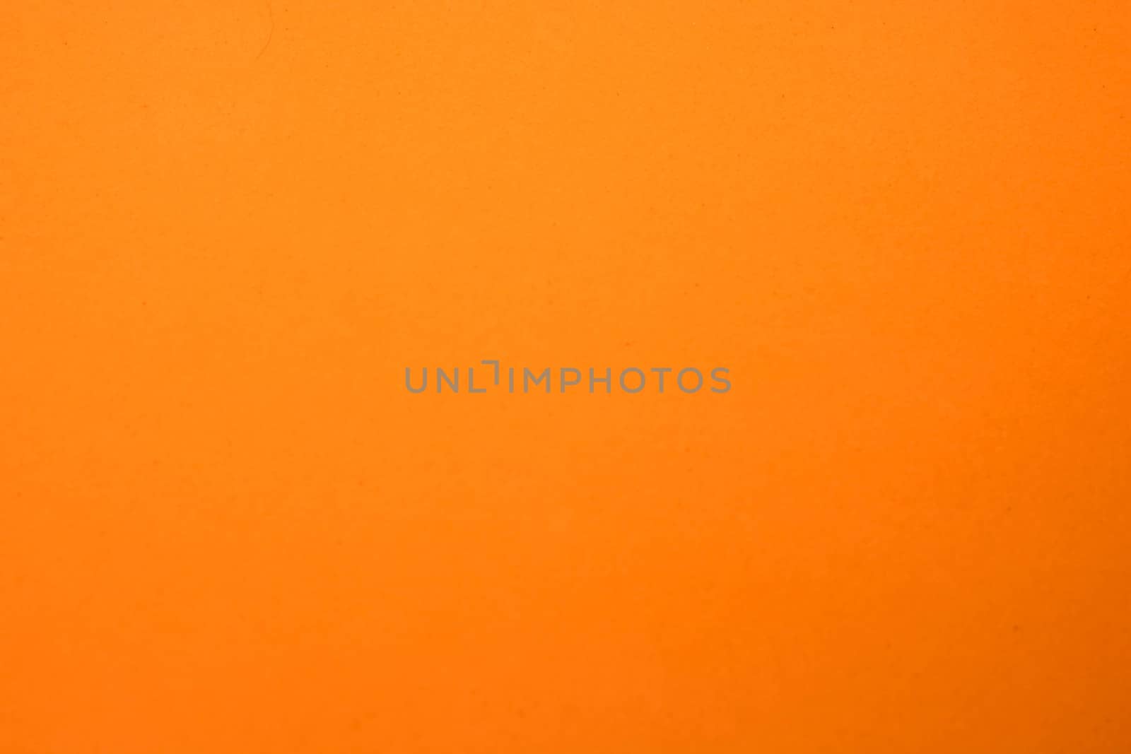 Light orange matte background of suede fabric, closeup. Velvet texture of seamless ginger woolen felt