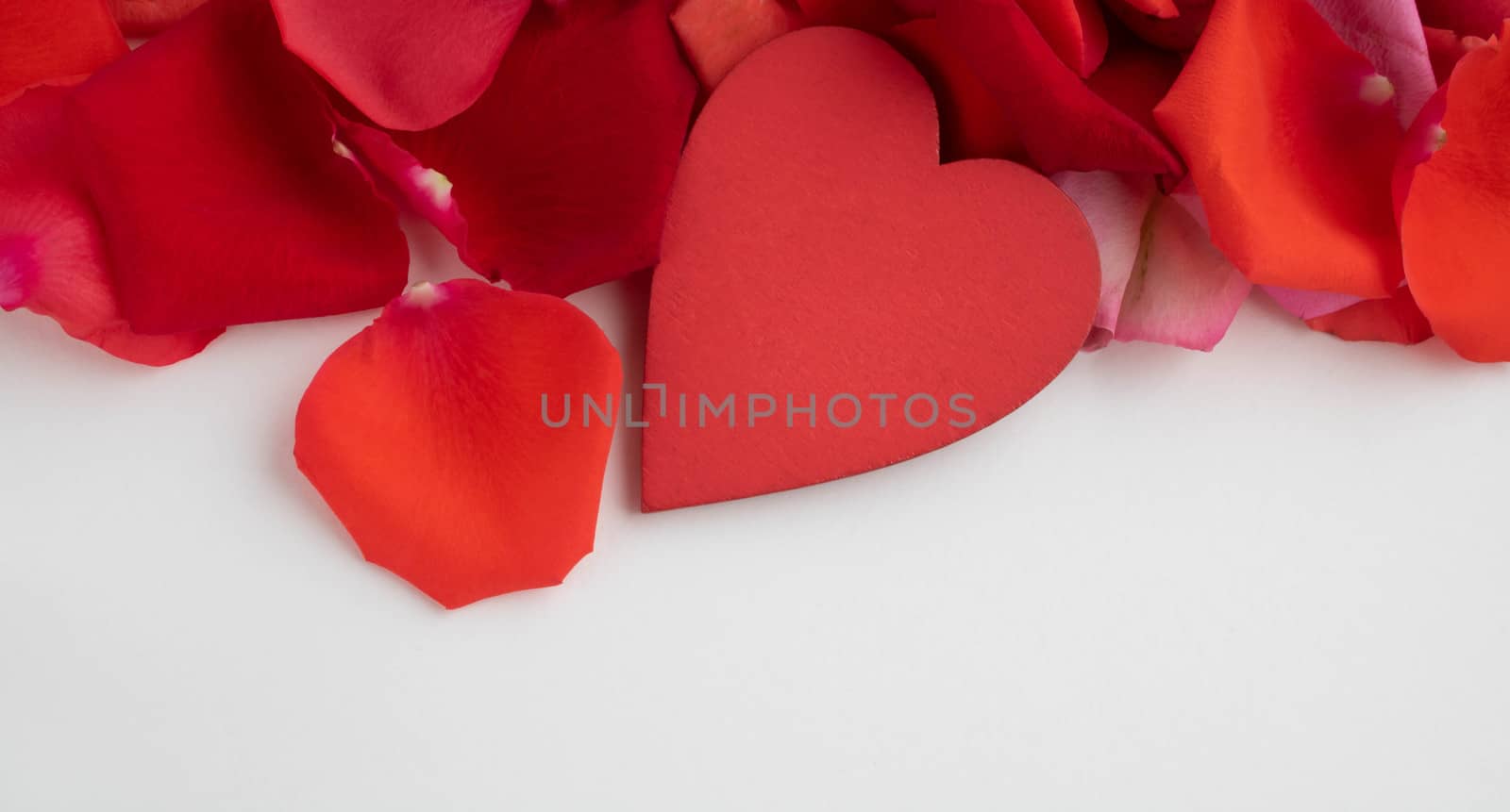 On the red rose petals is a red wooden heart.Concept of mother's Day, family Day, Valentine's Day, March 8 by lapushka62