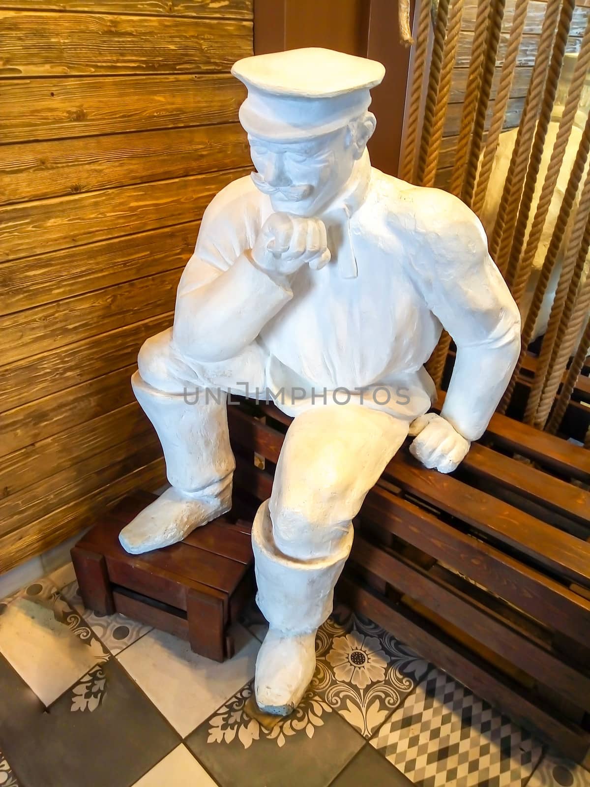 A white statue of a tired Miller sitting on a bench. Travel around the country