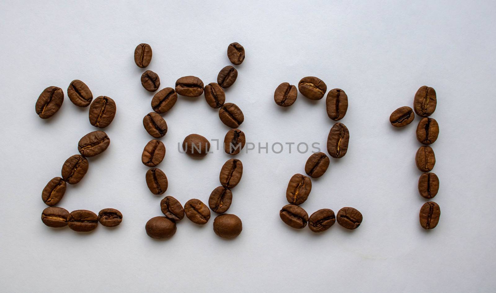 Image of the new year 2021 numbers from coffee beans on a white background