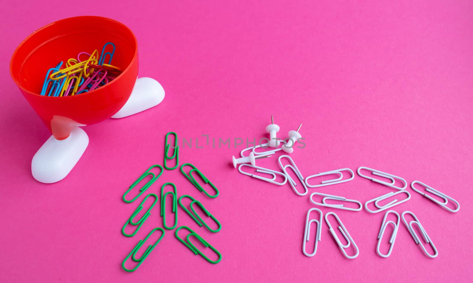 Year of the bull 2021.Colorful paper clips isolated on a pink background. Office supplies. Stapling documents and paper with paper clips.