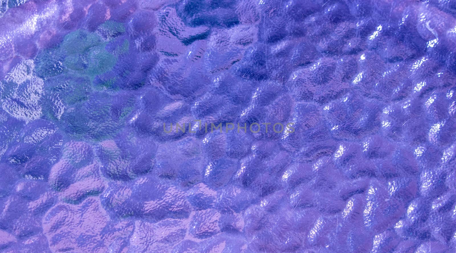 Abstract lilac glass close-up . Bubble glass surface