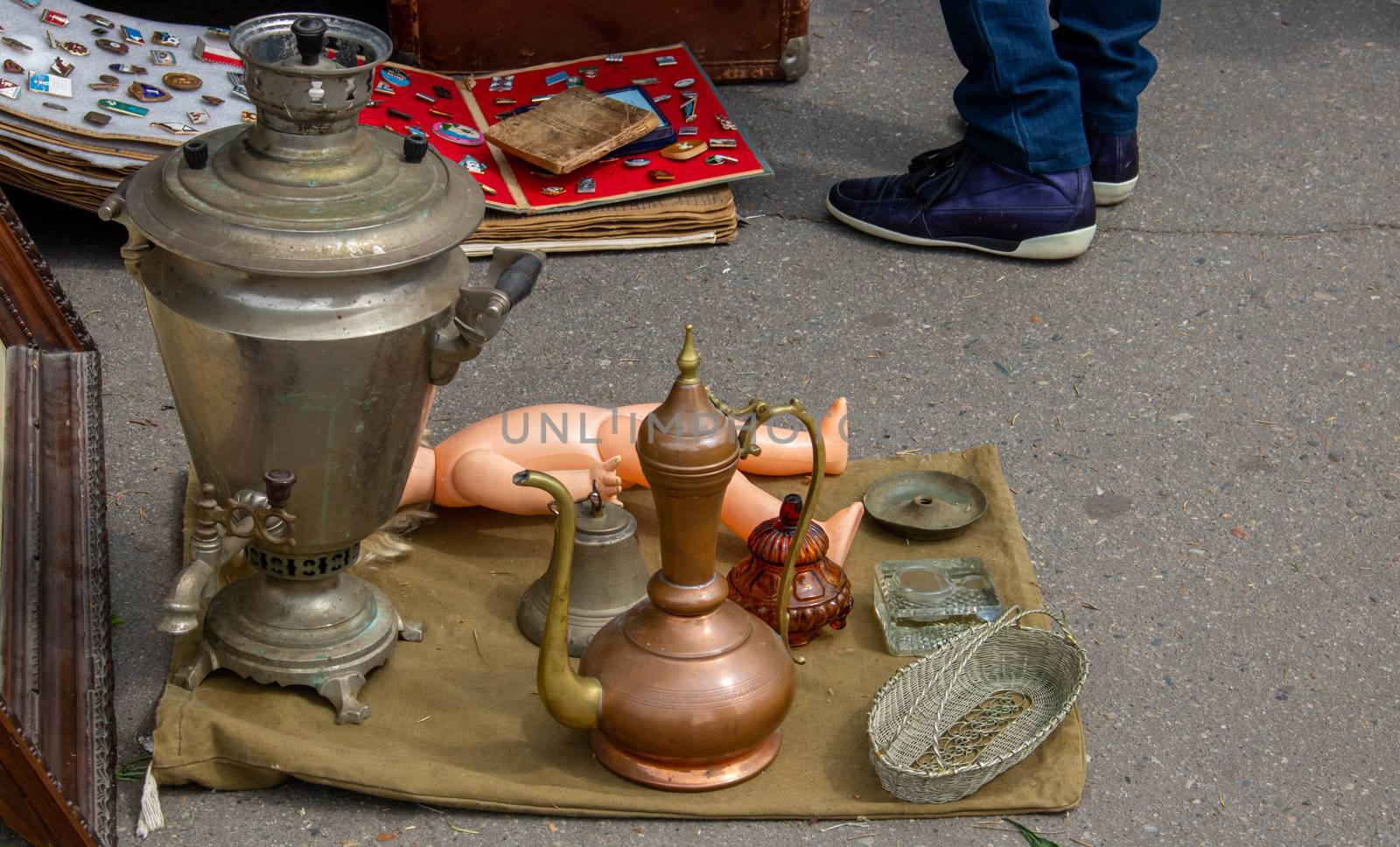 A group of various antique items on the asphalt at a flea market