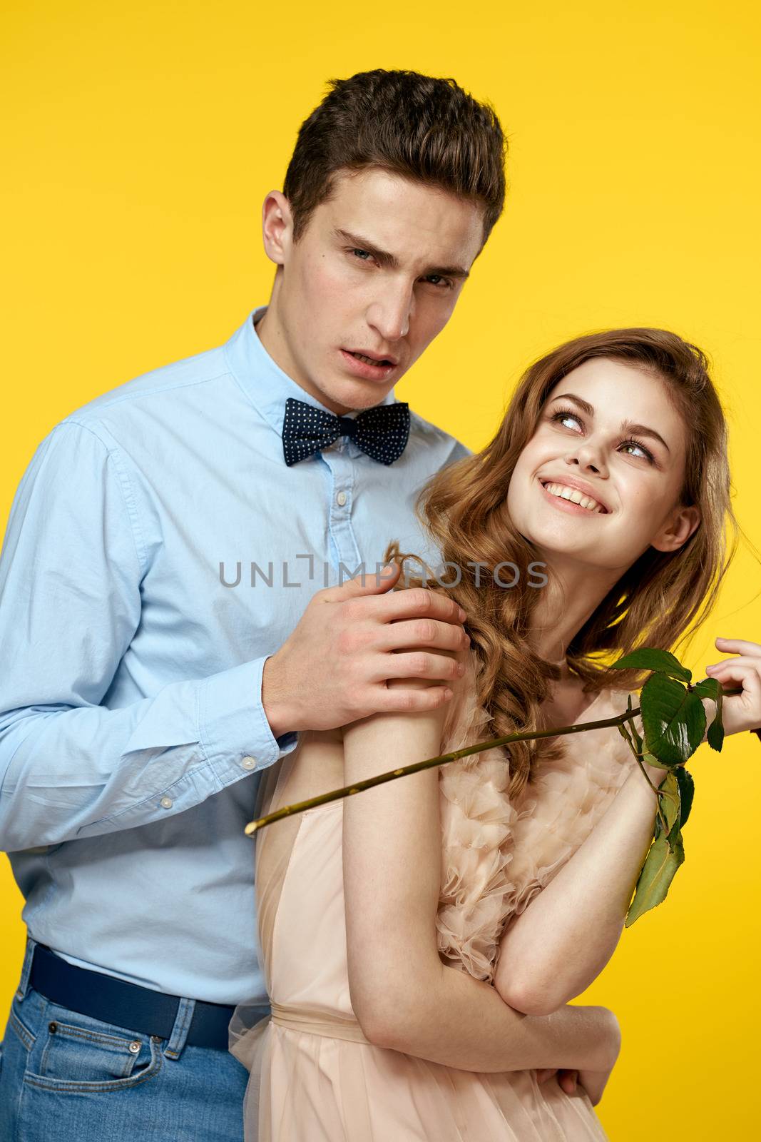 Enamored man and woman with red rose on yellow background cropped view close-up romance. High quality photo